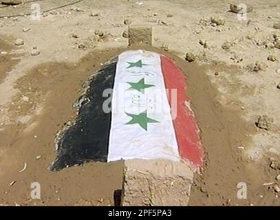 The unmarked grave of one of the elder sons of former Iraqi dictator Saddam Hussein is seen in the family cemetery in Tikrit, Iraq, on Saturday Aug. 2, 2003, wrapped in flags for a martyr's burial. The leaders of Saddam Hussein's tribe buried the ousted dictator's sons Uday and Qusai, together with Qusai's son Mustafa, who died together during a gun battle with US troops in Mosul on July 22. (AP photo / APTN)