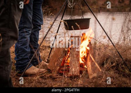 Cocinar al aire libre en una olla de hierro fundido sobre una fogata de  madera abierto en un campamento durante una recreación de la revolución  americana Fotografía de stock - Alamy