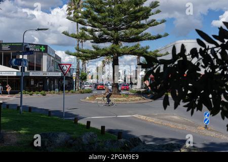 Tauranga Nueva Zelanda - 22 2023 de marzo; Tauranga Nueva Zelanda - 22 2023 de marzo; ciclista borroso en movimiento montando alrededor del jardín de la rotonda y la calle inter Foto de stock