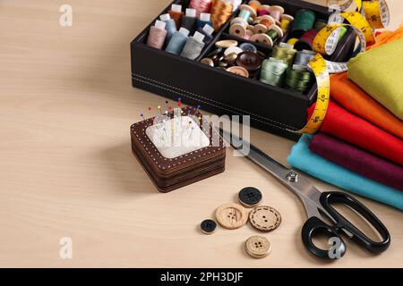 Conjunto de suministros de costura y accesorios en la mesa de madera Foto de stock