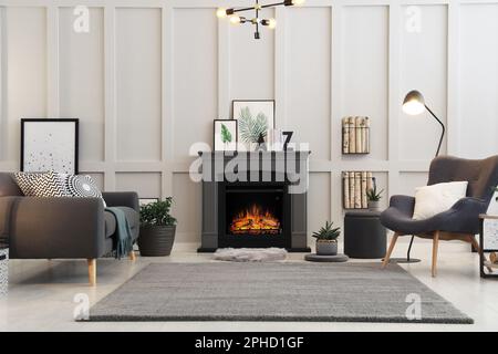 Elegante salón interior con chimenea eléctrica y muebles cómodos Fotografía  de stock - Alamy