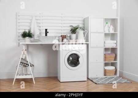 Moderna lavadora y estantería en el interior de la lavandería Fotografía de  stock - Alamy