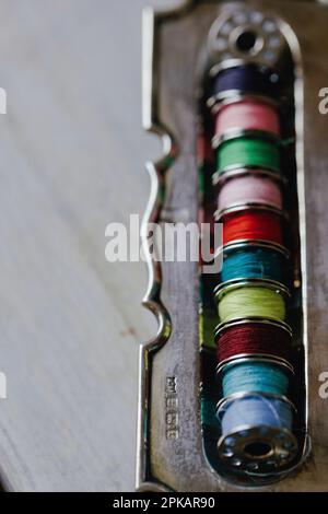 Carretes metálicos con hilo de coser en diferentes colores Foto de stock