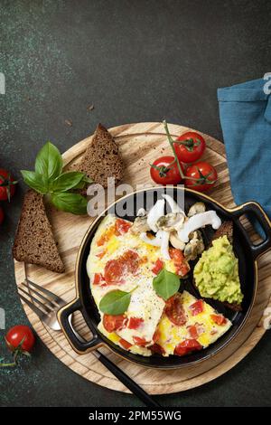 Omelette o tortilla con pimientos dulces y tomates, tosta pan con aguacate  y mariscos salados. Saludable dieta cetogénica bajo en carbohidratos  desayuno Fotografía de stock - Alamy