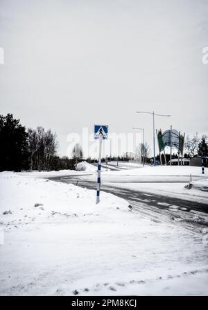 Carretera cubierta de nieve a través de la ciudad de Ivalo en Finlandia. Foto de stock