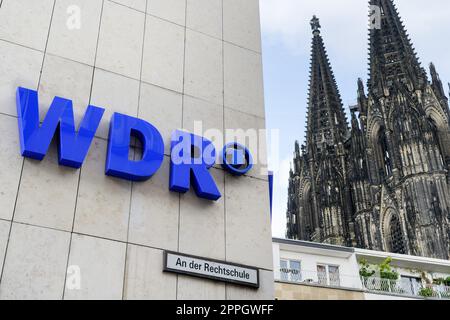 El logotipo de wdr en el edificio de la Colonia de Radiodifusión de Alemania Occidental con la catedral en el fondo Foto de stock
