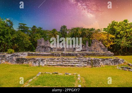 Lagarto de Iguana en antiguas ruinas de Maya en la Zona Arqueológica de El Rey cerca de Cancún, Yukatan, México con la Vía Láctea estrellas de cielo nocturno Foto de stock