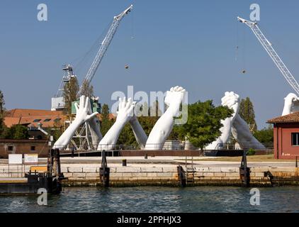 Escultura de manos unidas gigantes Construyendo puentes por Lorenzo Quinn. Exposición en Arsenale, Castello, Venecia Foto de stock