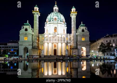 VIENNA, AUSTRIA - AUGUST 30: Tourists at the illuminated Baroque Karlskirche in Vienna, Austria on August 30, 2017. The church is considered the most Stock Photo