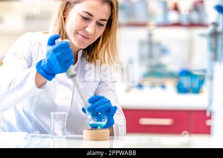 una joven científica lleva a cabo experimentos químicos en un laboratorio de investigación Foto de stock