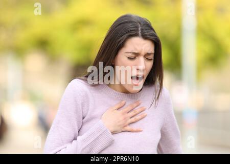 Adolescente estresado que tiene problemas respiratorios en un parque Foto de stock