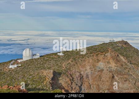 Observatorio del Roque de los Muchachos en La Palma. Un observatorio astronómico en la cima de una montaña con espacio de copia de cielo azul. Telescopio rodeado de vegetación y situado en una isla en el borde del acantilado. Foto de stock