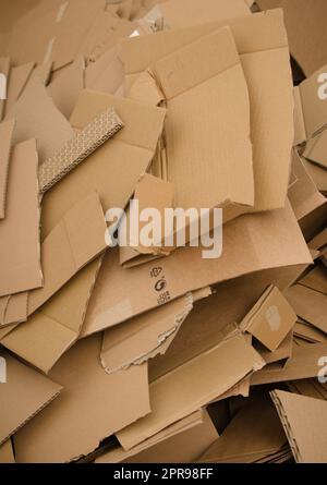 Una gran cantidad de cartón cortado en una pila grande. La foto muestra la cantidad de residuos generados por el embalaje de cartón. Foto de stock