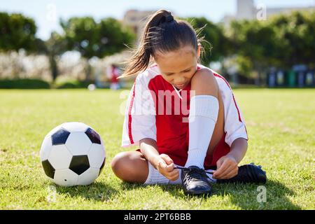Deportes, fútbol y zapatos de corbata con niña en hierba para fitness, juegos y entrenamiento en el evento de brasil. Motivación, entrenamiento y con el niño Fotografía de stock -