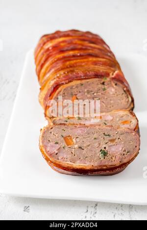 Bacon envuelto Meatloaf en el plato blanco Foto de stock