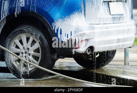 Limpieza del coche con espuma. Lavar el coche blanco con jabón en  auto-servicio de lavado de coches Fotografía de stock - Alamy