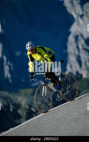 Ciclista de carreras en un tramo cuesta abajo, Cortina d' Ampezzo, Dolomitas, Italia Foto de stock