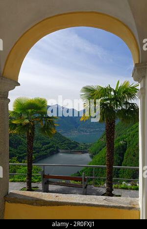 Vista a través de un arco al Lago di Vogorno con el lago Maggiore en el fondo, Mergoscia, Ticino, Suiza Foto de stock