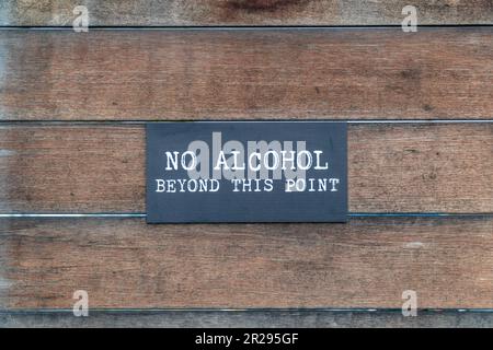 Letrero que lee 'No hay alcohol más allá de este punto' con pared de madera Foto de stock