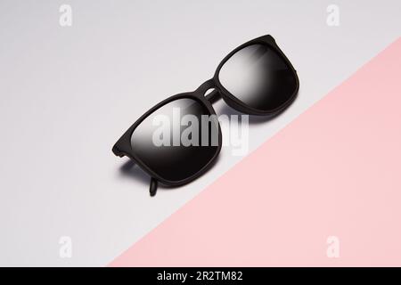 Las gafas de sol, las sombras dobladas se encuentran diagonalmente en rosa. Foto de stock
