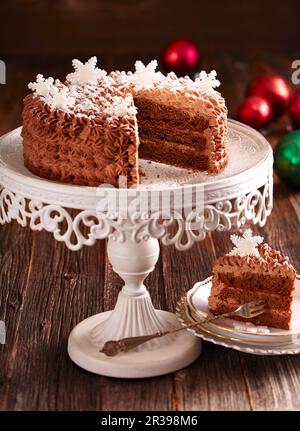 Un pastel festivo de ron-trufa con crema de chocolate y copos de nieve fondant Foto de stock