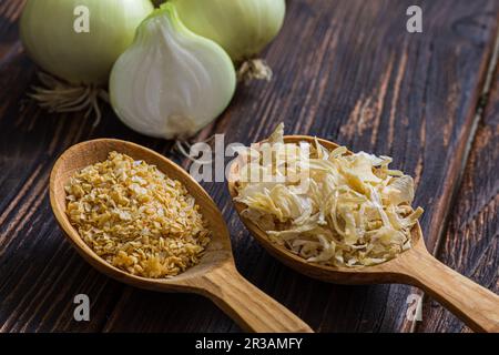 Dos cucharas de madera con condimentos de cebolla en diferentes formas Foto de stock