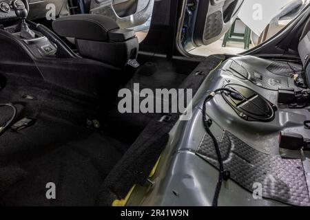 El trabajador del servicio tunning instala material de insonorización  dentro del interior del coche
