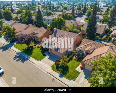 Vista aérea de una zona residencial en los suburbios con un camino pavimentado que serpentea a través del barrio Foto de stock