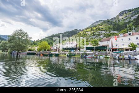 El pueblo de Rijeka Crnojevica fotografiado desde un barco se centra en el turismo y los viajes al lago Skadar, fotografiado en Montenegro en mayo de 2023. Foto de stock