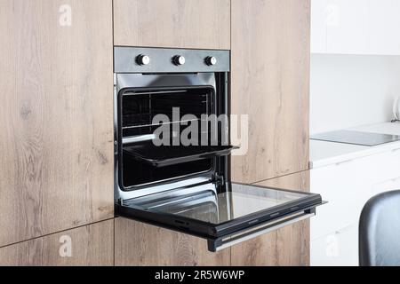 Cocina contemporánea con horno de lavavajillas abierto empotrado cuadrado fregadero  negro encimera de gas con encimera de gres porcelánico gris y armarios  Fotografía de stock - Alamy