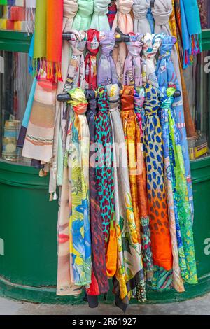 Mano femenina sosteniendo la seda colorida mano pintada atada bufanda sobre  fondo gris. Moda de la mujer, atando una bufanda, usando una bufanda.  Formas elegantes de atar Fotografía de stock - Alamy