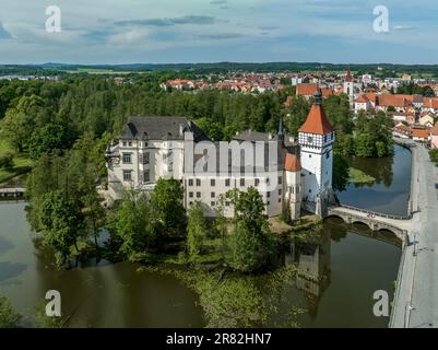 Vista aérea del castillo medieval de agua de Blatna con torres, torretas, además de extensos terrenos en Bohemia Foto de stock