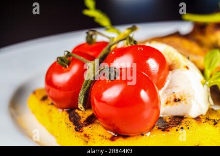 Un plato de comida con tomates y mozzarella Foto de stock
