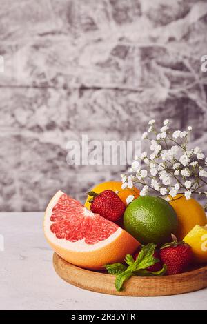 Frutas cítricas sanas frescas estéticas en plato de madera. Vitaminas orgánicas y naturales. Copiar espacio. Foto de stock