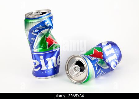Ciudad Ho Chi Minh, Vietnam - 16 de junio de 2023: 2 latas de cerveza de aluminio triturado con el logotipo de Heineken aislado en blanco. Abrió una lata arrugada vacía de una famou Foto de stock