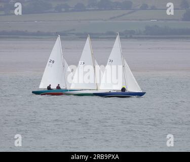 Tres keelboats de la clase Fife One Design que compiten frente a Beaumaris en el estrecho de Menai Foto de stock
