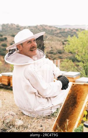 Vista lateral del apicultor masculino con disfraz protector