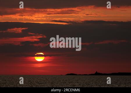 Puesta de sol sobre el mar de Irlanda en Dinas Dinlle en la costa del norte de Gales Foto de stock
