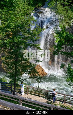 Los visitantes admiran la cascada de Hrvoje (Slap Hrvoje en croata) en el pueblo de Rastoke en Slunj-Slapovi en la confluencia de Slunjcica y K Foto de stock