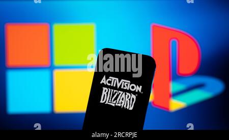 Los logotipos de Sony PlayStation y Microsoft se ven en el fondo con el logotipo de Activision Blizzard en un dispositivo móvil en esta ilustración Foto de stock