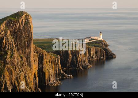 Sol al atardecer en verano en el faro y los acantilados de basalto en Neist Point en la isla de Skye Foto de stock