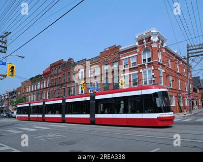 Tranvía de Toronto en Queen Street West con fachadas ornamentadas de edificios victorianos antiguos en el fondo Foto de stock