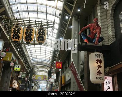 Spiderman y McDonalds son dos de los iconos reconocibles en la calle comercial cubierta Shin Nakamise en Asakusa, una concurrida zona turística de Tokio. Foto de stock