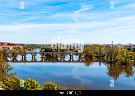 Vista escénica del río Duero y Puente de Piedra, Puente de Piedra, con reflejos sobre el agua. Zamora, España Foto de stock