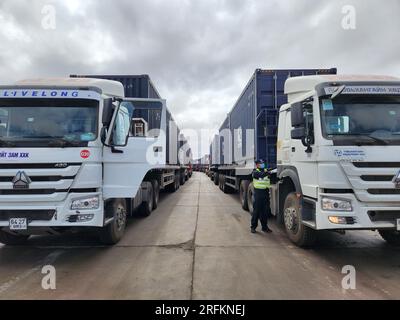 Hohhot. 31º de julio de 2023. Esta foto tomada el 31 de julio de 2023 muestra a una policía fronteriza inspeccionando camiones de carga en el puerto de Ganqmod en la ciudad de Bayannur, región autónoma de Mongolia Interior al norte de China. PARA IR CON 'el puerto fronterizo entre China y Mongolia ve un aumento del volumen de mercancías' crédito: Li Yunping / Xinhua / Alamy Live News Foto de stock