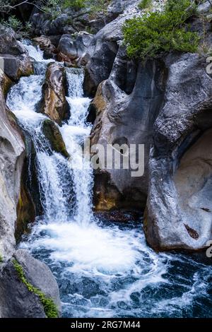 Un hermoso desfiladero de montaña con un río y una cascada Foto de stock