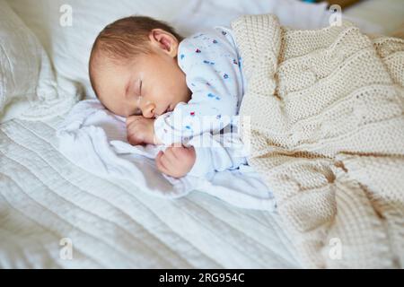 Bebé recién nacido durmiendo debajo de la manta de punto Fotografía de stock  - Alamy