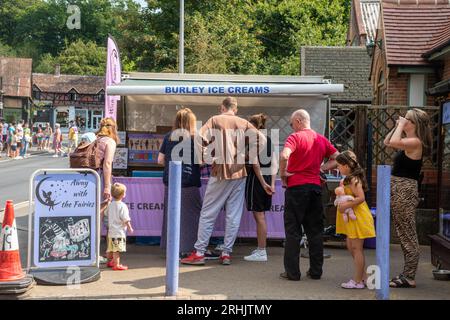 Gente que compra helados en el pueblo de Burley en el Parque Nacional de New Forest en un día de verano, Hampshire, Inglaterra, Reino Unido Foto de stock