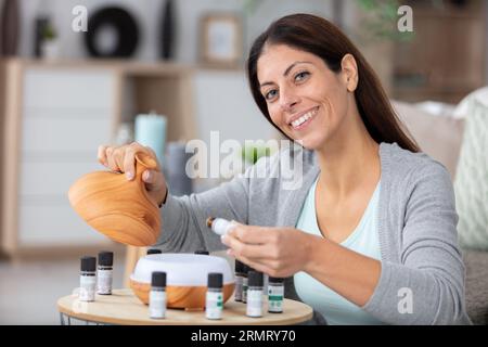 Mujer joven aplicando aceites esenciales a su muñeca Fotografía de stock -  Alamy