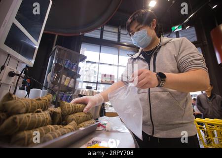 200617 -- SYDNEY, June 17, 2020 -- Yan Zhe, the manager of the Ustore supermarket, packs Zongzi, a traditional Chinese food made of glutinous rice wrapped in bamboo leaves, for customers in Sydney, Australia, on June 17, 2020. The Ustore supermarket in Sydney offers Zongzi delivery service to Chinese people living in the city ahead of the upcoming Dragon Boat Festival. Photo by /Xinhua AUSTRALIA-SYDNEY-DRAGON BOAT FESTIVAL-ZONGZI HuxJingchen PUBLICATIONxNOTxINxCHN Stock Photo